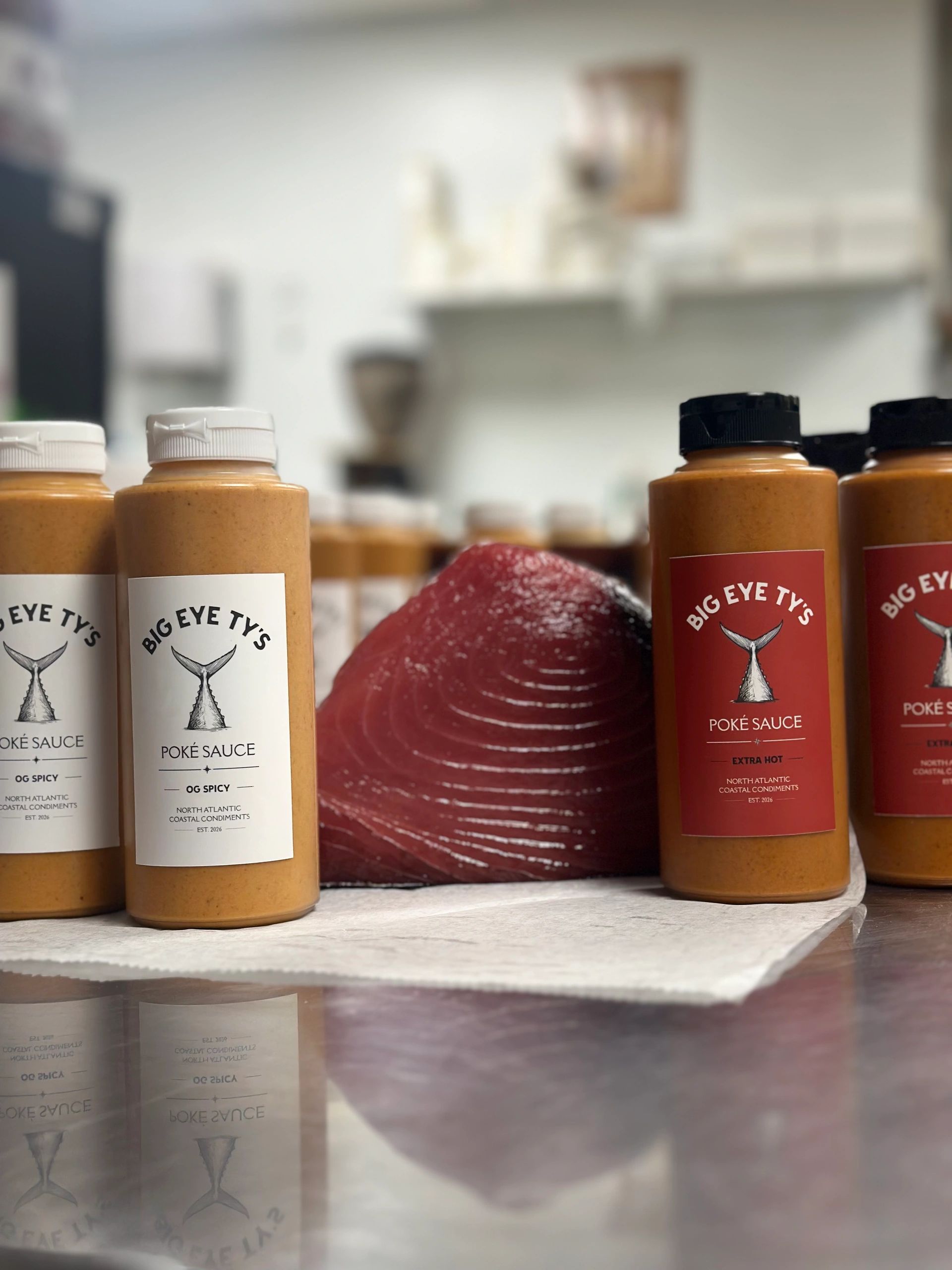 Big Eye Ty's poké sauce bottles next to fresh tuna